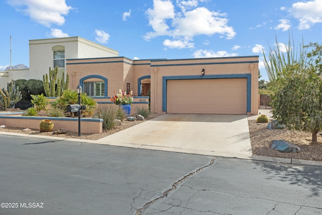 view of front of home with driveway, an attached garage, and stucco siding