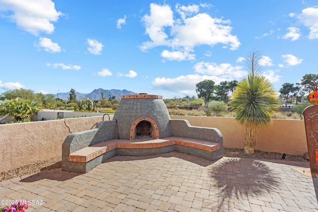 view of patio / terrace with a mountain view and an outdoor fireplace