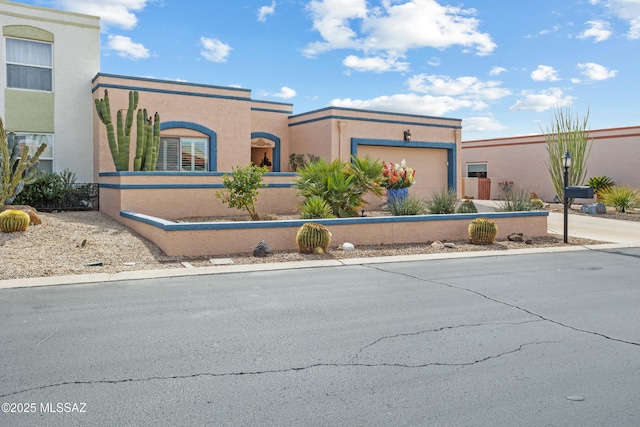 view of front of house featuring a fenced front yard, an attached garage, and stucco siding