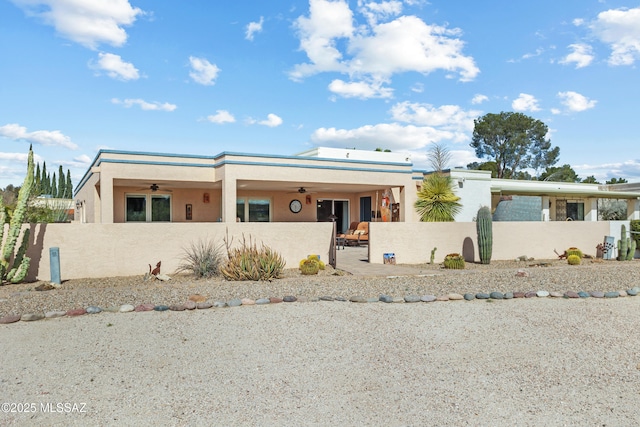 view of front of property with a fenced front yard, ceiling fan, a patio, and stucco siding