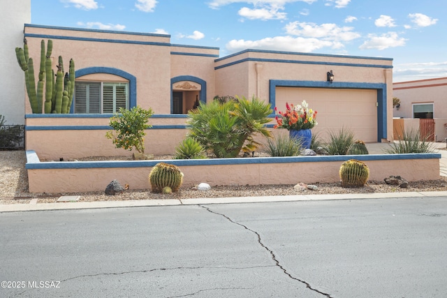 view of front of home with a fenced front yard, a garage, and stucco siding