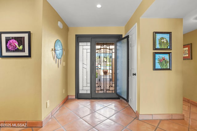 tiled foyer entrance with baseboards