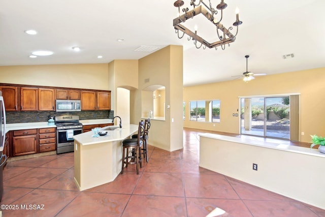 kitchen with visible vents, stainless steel appliances, tile patterned flooring, light countertops, and open floor plan