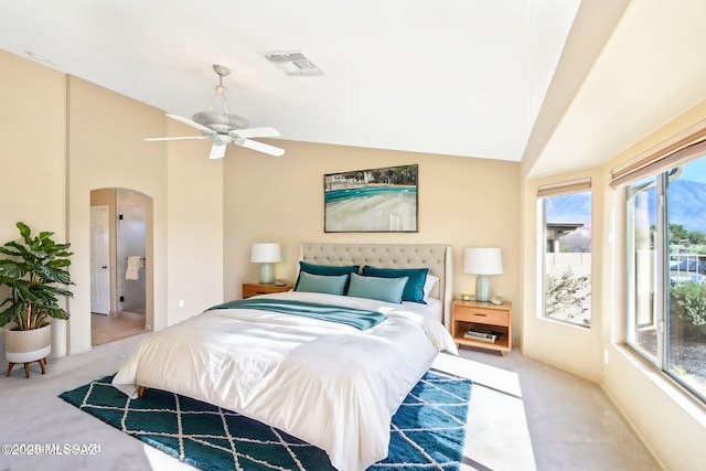 carpeted bedroom with arched walkways, visible vents, lofted ceiling, and access to outside