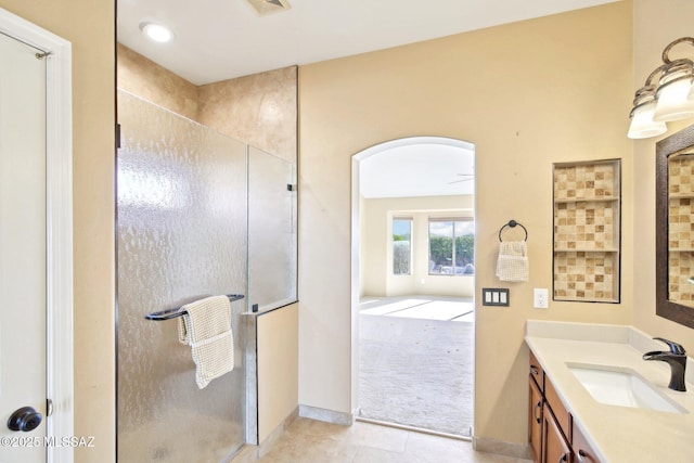 bathroom with tile patterned floors, a stall shower, vanity, and baseboards