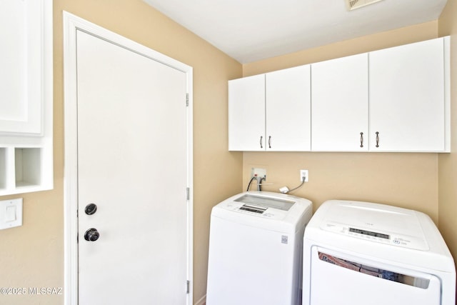 washroom with separate washer and dryer, cabinet space, and visible vents