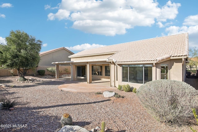 back of property featuring a tile roof, a patio area, fence, and stucco siding