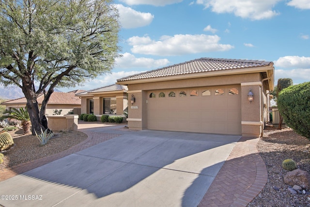 view of front of property featuring a tile roof, concrete driveway, a garage, and stucco siding