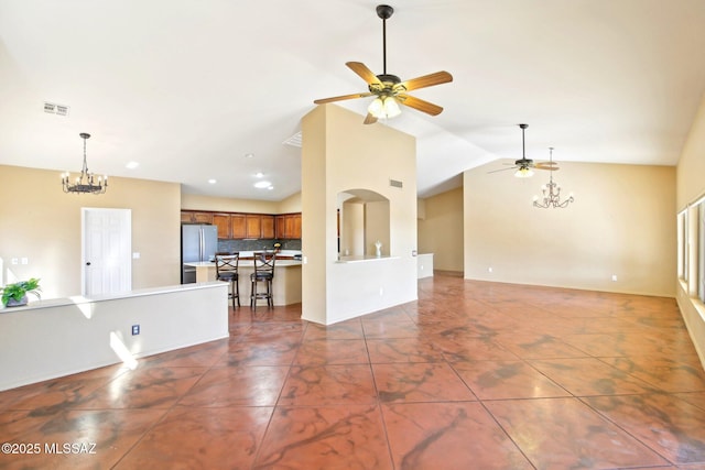 unfurnished living room featuring visible vents, baseboards, vaulted ceiling, recessed lighting, and ceiling fan with notable chandelier