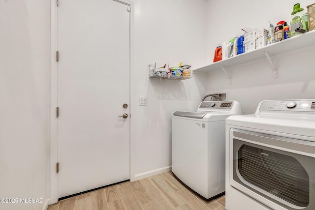 laundry room featuring laundry area, washer and dryer, light wood-type flooring, and baseboards