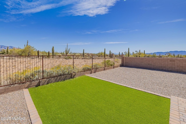 view of yard featuring a mountain view and a fenced backyard