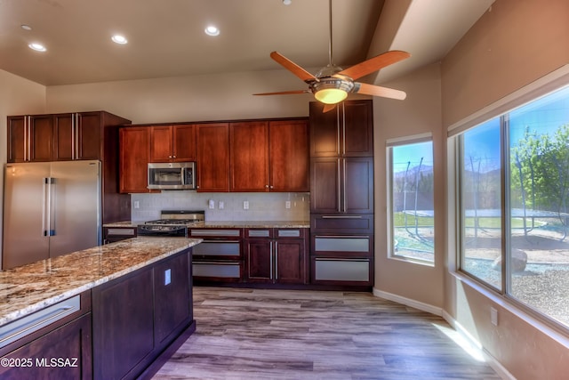 kitchen with tasteful backsplash, a healthy amount of sunlight, stainless steel appliances, and ceiling fan