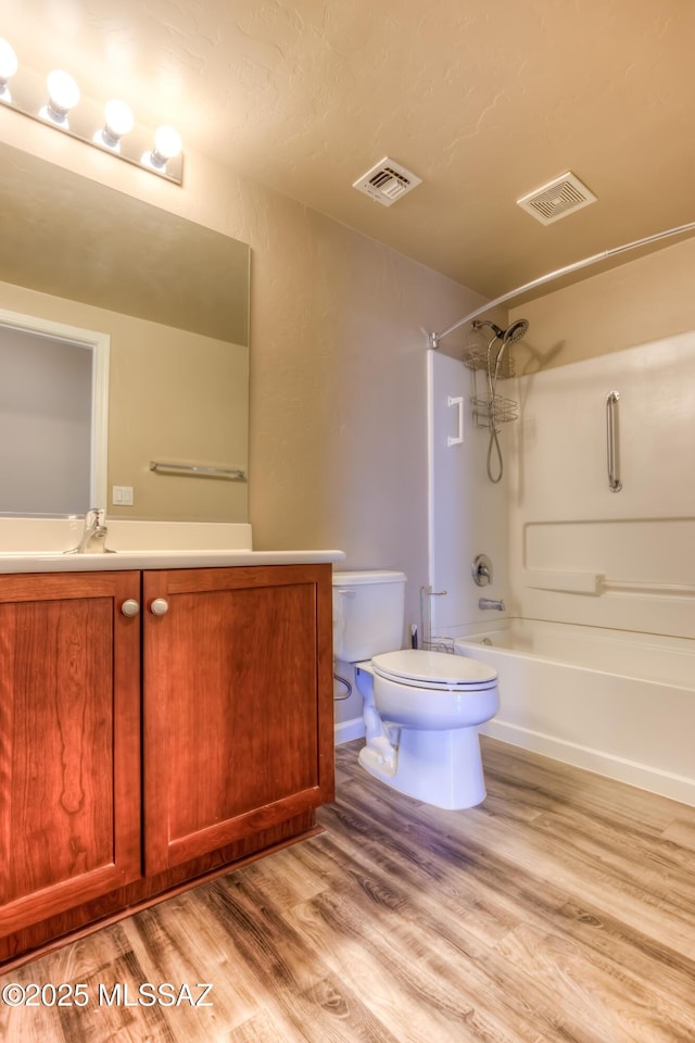 bathroom with visible vents, toilet, shower / bath combination, and wood finished floors