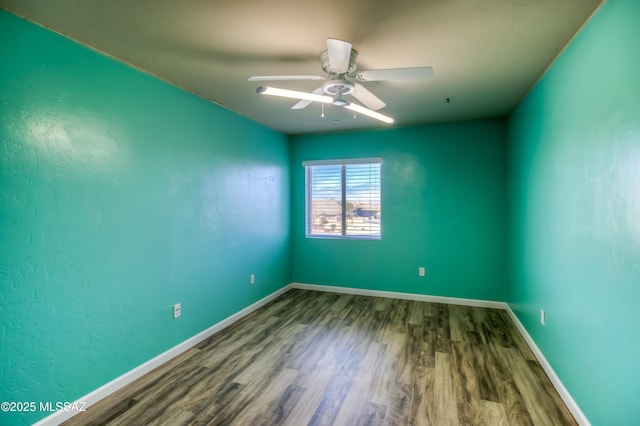 unfurnished room with a ceiling fan, wood finished floors, and baseboards