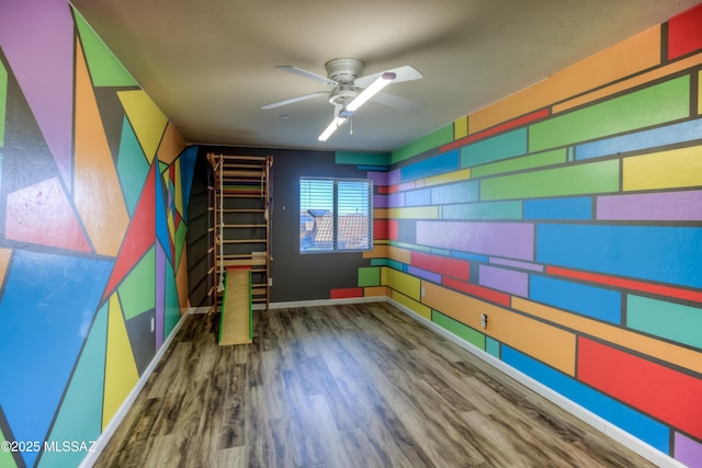 playroom featuring baseboards, a ceiling fan, and wood finished floors