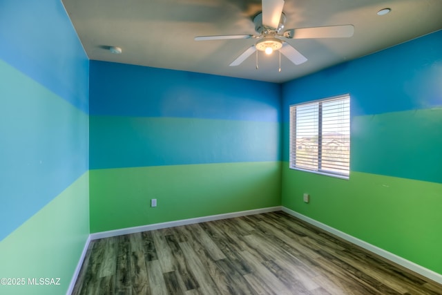 spare room featuring wood finished floors, baseboards, and ceiling fan