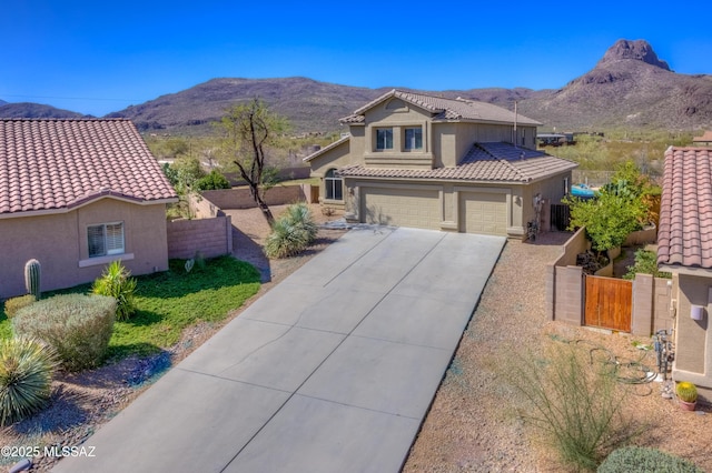 view of front of property with fence, a tile roof, stucco siding, a garage, and a mountain view