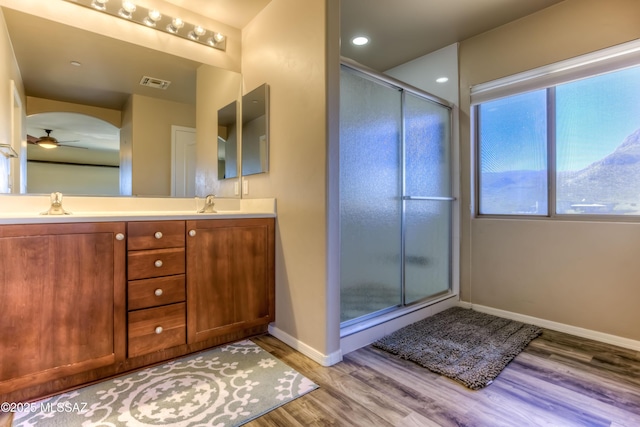 bathroom featuring visible vents, wood finished floors, ceiling fan, and a shower stall