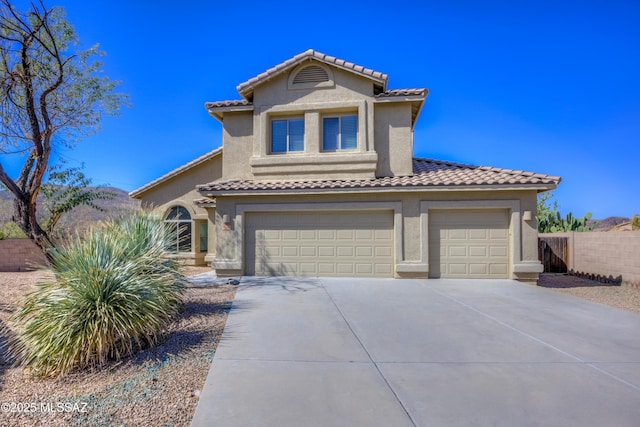 mediterranean / spanish-style home featuring fence, concrete driveway, a tile roof, stucco siding, and a garage