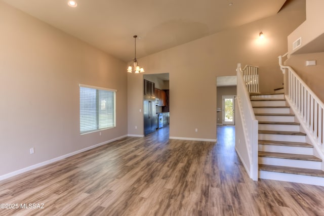 interior space featuring visible vents, baseboards, wood finished floors, and stairs