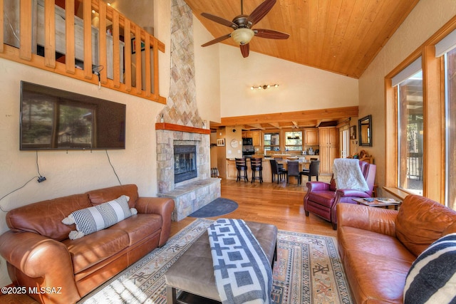 11085 E Grosbeak Ln, Mount Lemmon, AZ 85619 - living area with a stone fireplace, wood finished floors, a ceiling fan, wood ceiling, and high vaulted ceiling