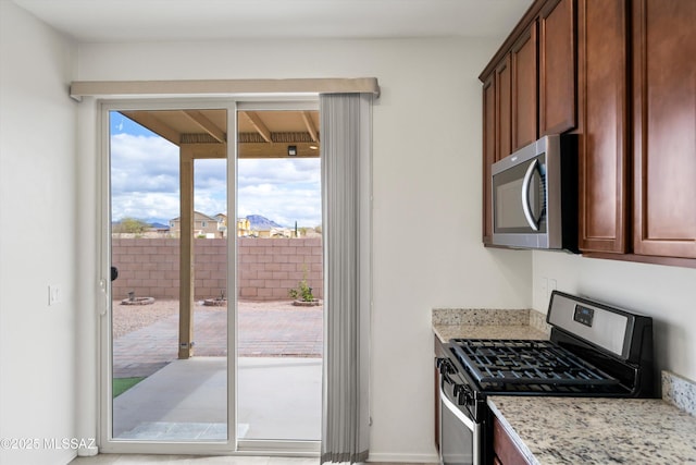 kitchen featuring light stone counters and stainless steel appliances