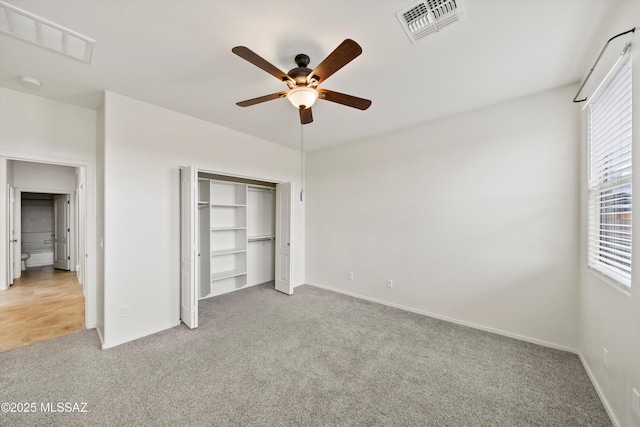 unfurnished bedroom with visible vents, light carpet, a closet, and a ceiling fan