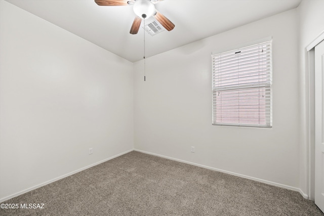 carpeted empty room featuring visible vents, baseboards, and ceiling fan