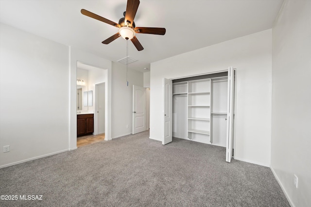 unfurnished bedroom with baseboards, light carpet, attic access, and a closet