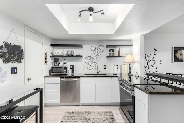 7071 E Corto Caravaca, Tucson, AZ 85715 - kitchen featuring a sink, light wood-type flooring, open shelves, and stainless steel appliances