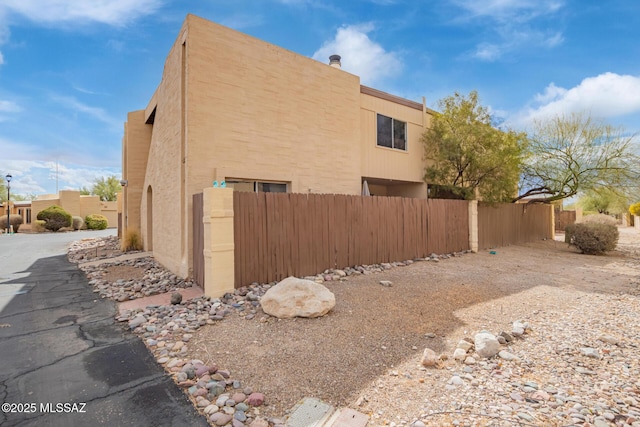 view of home's exterior with fence and stucco siding