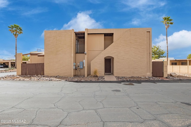 view of front of house featuring stucco siding and fence