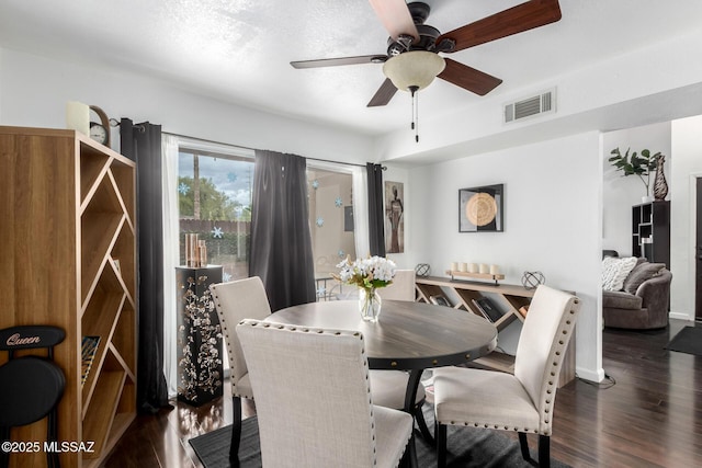 dining room featuring ceiling fan, visible vents, and wood finished floors