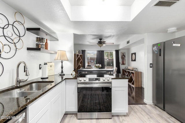 kitchen with visible vents, open shelves, appliances with stainless steel finishes, a peninsula, and a sink