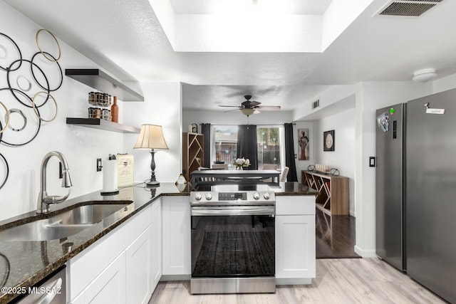 7071 E Corto Caravaca, Tucson, AZ 85715 - kitchen with a peninsula, open shelves, visible vents, appliances with stainless steel finishes, and a sink