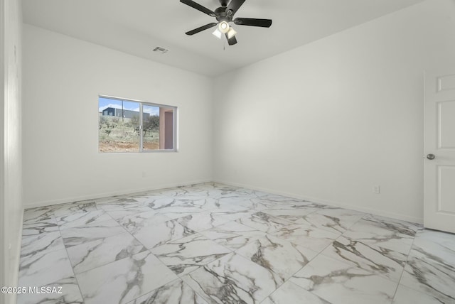 spare room featuring ceiling fan, marble finish floor, visible vents, and baseboards