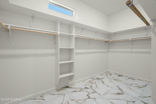 walk in closet featuring marble finish floor