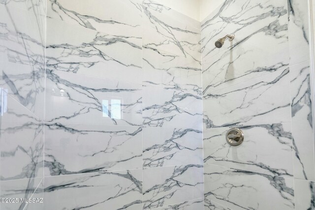 interior details featuring a marble finish shower