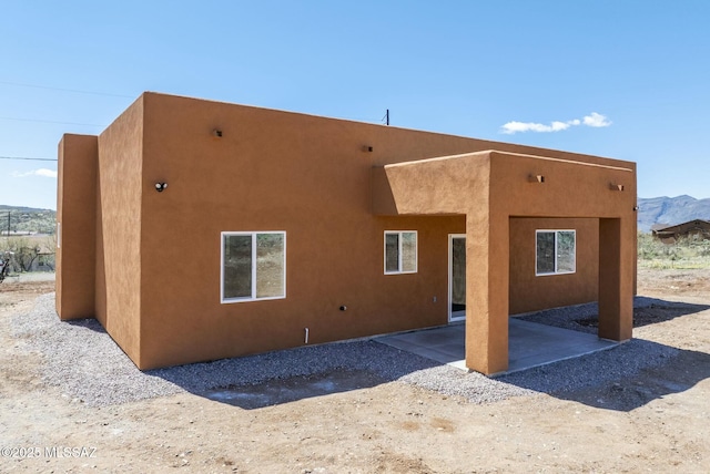 rear view of property featuring a patio area and stucco siding