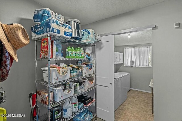 laundry room featuring cabinet space, baseboards, washer and dryer, and a textured ceiling
