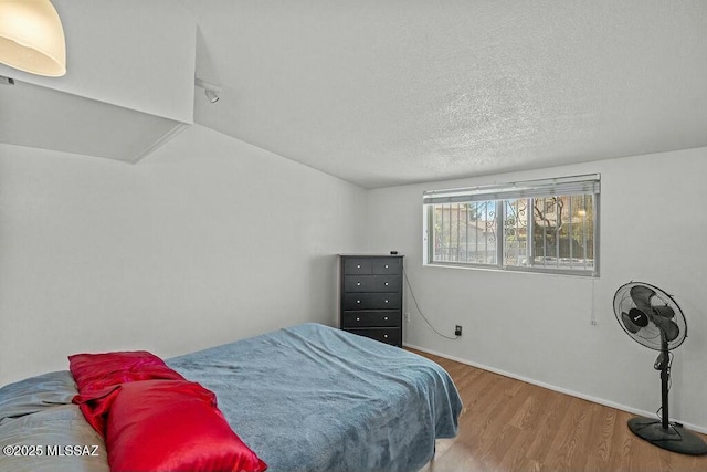 bedroom featuring wood finished floors and a textured ceiling