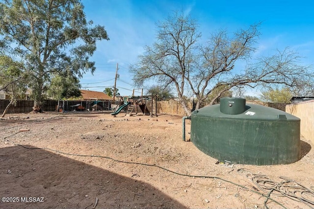 view of yard with a fenced backyard and a playground