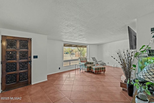 interior space with tile patterned floors, baseboards, and a textured ceiling