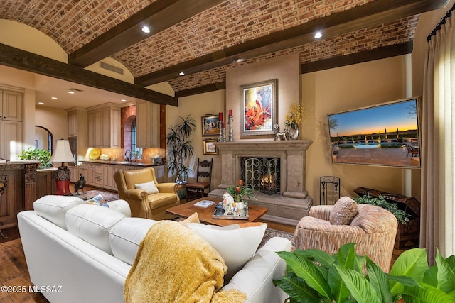 interior space featuring lofted ceiling, dark wood-style floors, brick ceiling, a lit fireplace, and recessed lighting