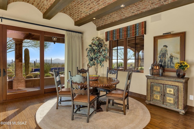 dining space featuring brick ceiling, visible vents, hardwood / wood-style flooring, and baseboards