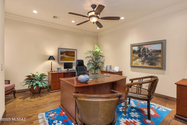 office area with light wood-style floors, visible vents, and crown molding