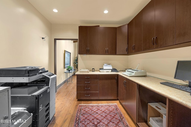 kitchen featuring recessed lighting, light countertops, dark brown cabinetry, and light wood finished floors