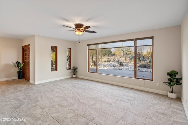 empty room with ceiling fan, baseboards, and light tile patterned floors