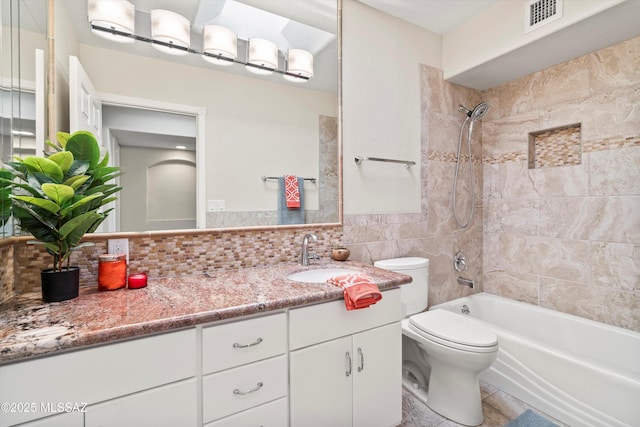 full bathroom with toilet, bathing tub / shower combination, vanity, visible vents, and tile walls