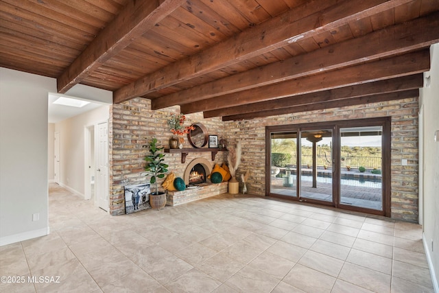 unfurnished living room with light tile patterned floors, wood ceiling, baseboards, a brick fireplace, and beamed ceiling